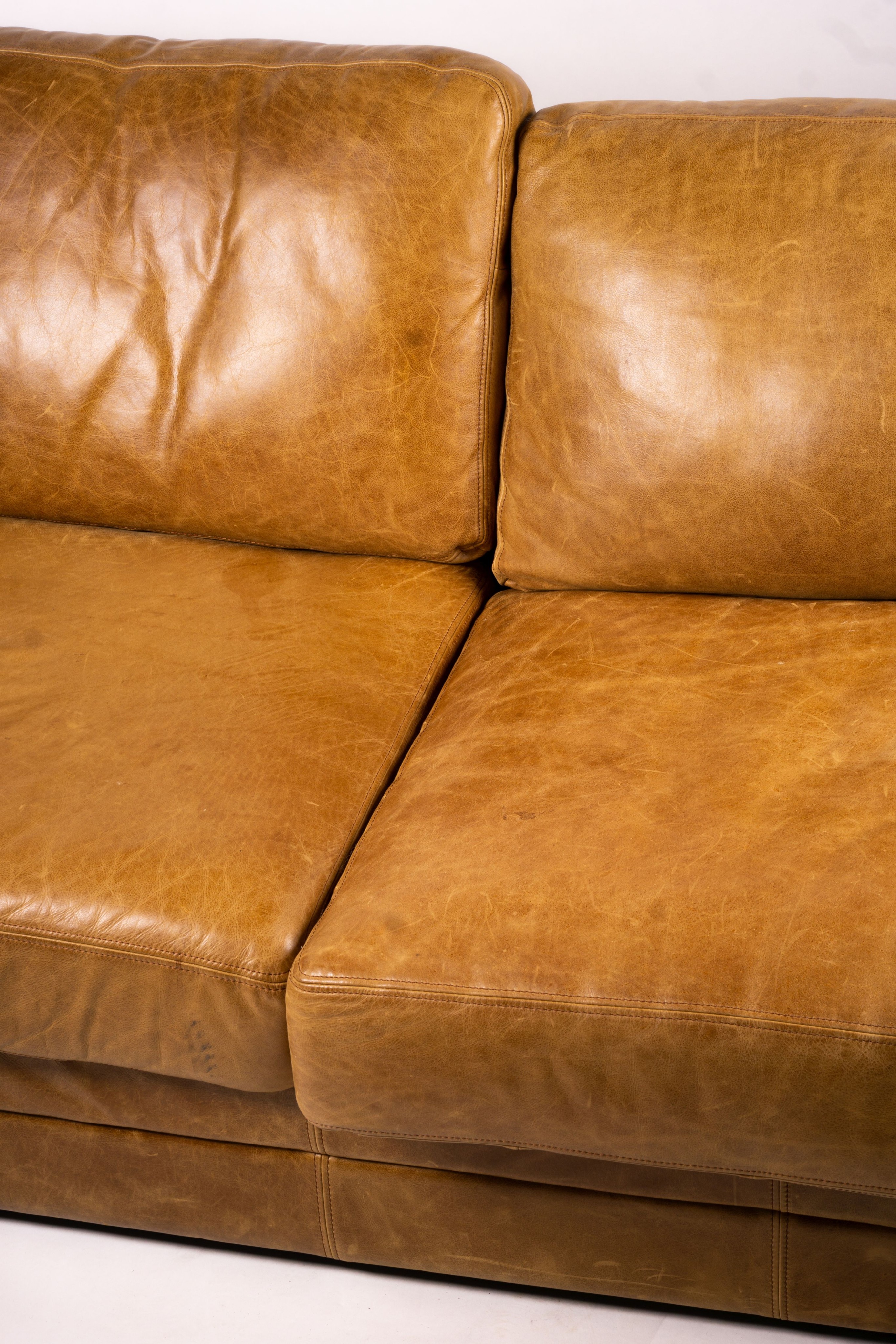 A pair of contemporary tan leather settees, length 200cm, depth 100cm, height 94cm